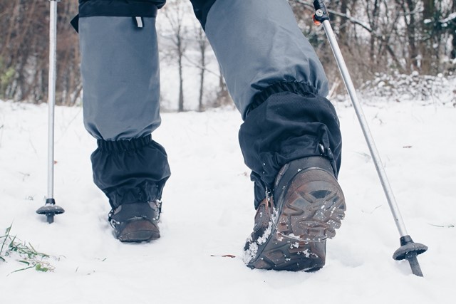 Wandelaar draagt korte gamaschen tijdens wandeling in de sneeuw