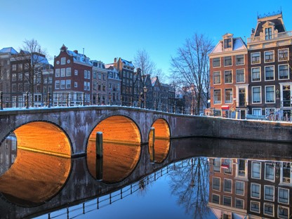 afbeelding van een Amsterdamse gracht in de schemering.