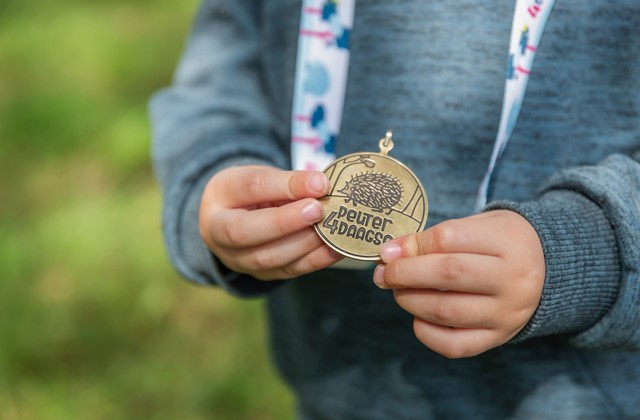 Kinderhanden tonen medaille Peuter4daagse