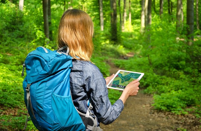 Wandelaar met tablet in bos