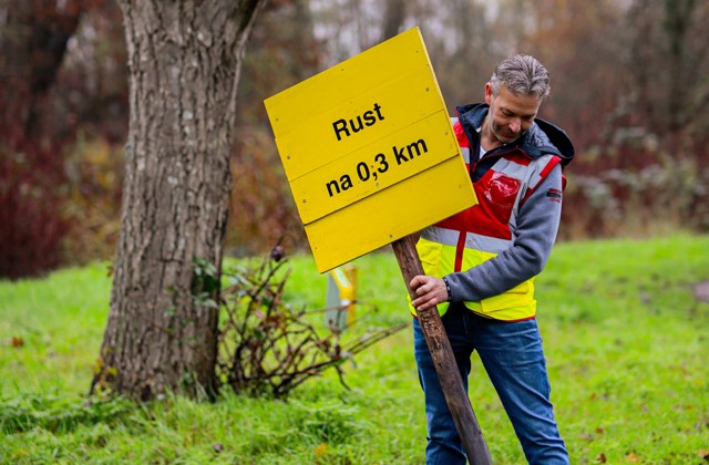 Vrijwilliger plaatst bord Rustpost