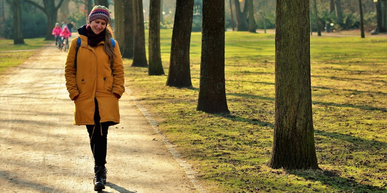 afbeelding van een vrouw die in het park wandelt.