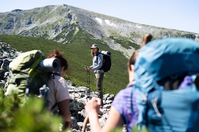Rick met een hoed in de zonnige bergen in Bulgarije, met bepakking.