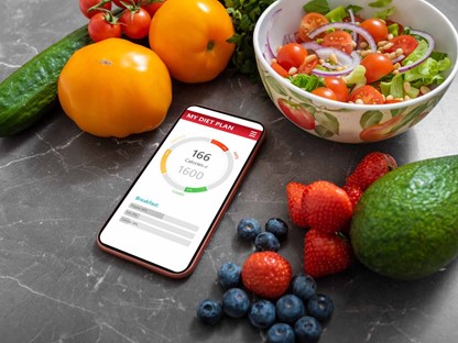 voedingsmiddelen en een telefoon met een app die calorieën telt